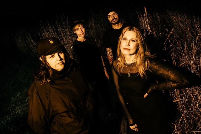 Stabbitha and the Knifey Wifeys dressed in black standing in a field
